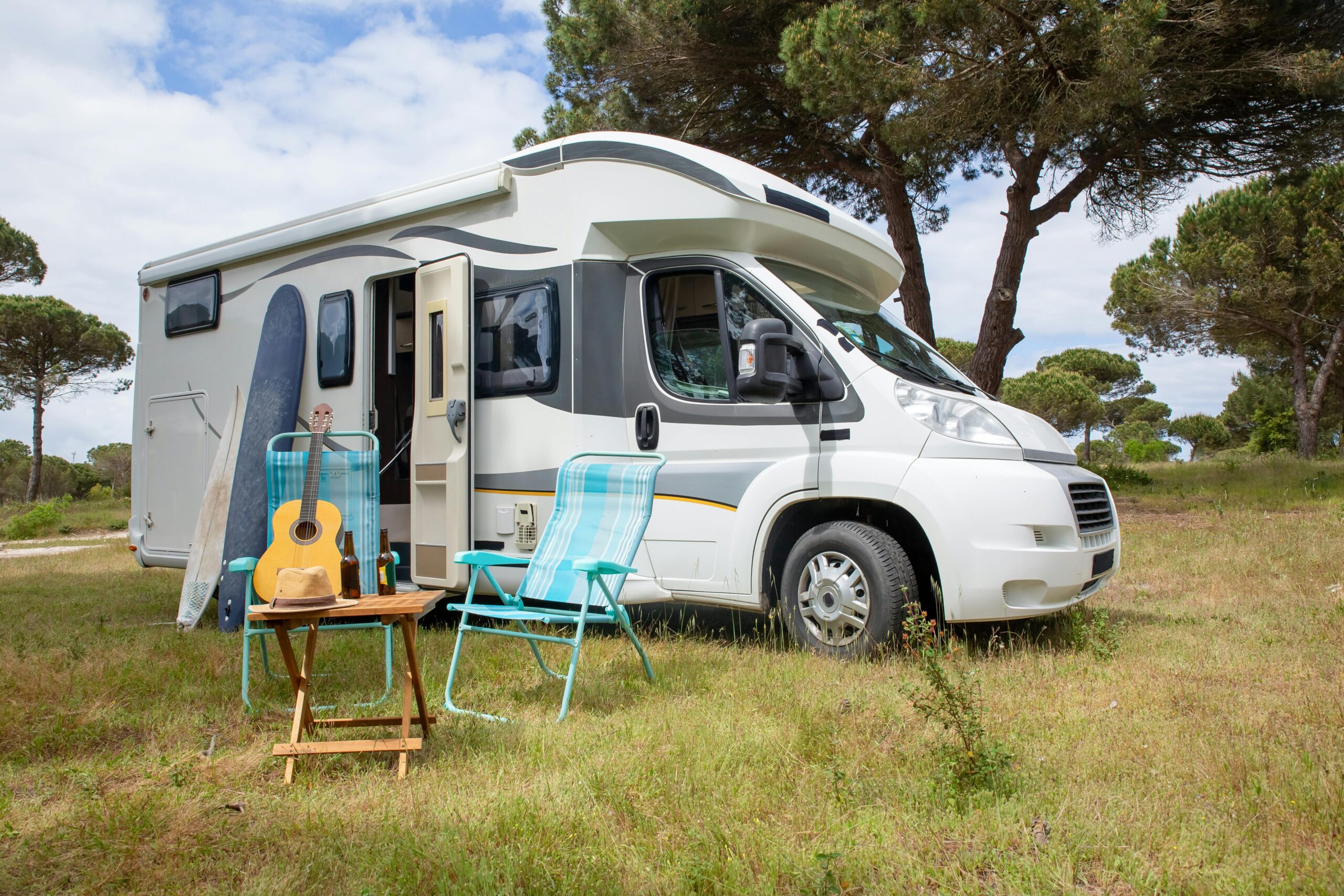 Image with RV and chairs set up outside on grass showing RV Living.